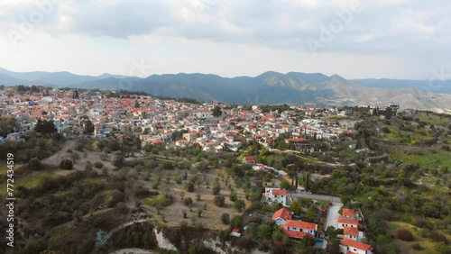 Aerial zoom out view popular tourist attraction Pano Lefkara village on Cyprus, Europe. Flying over majestic cityscape with greek orthodox church on the beautiful green hills photo