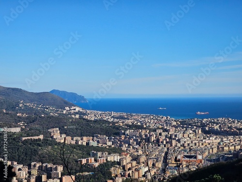 Genova, Italy - March 24, 2024: Aereal view to the city of Genoa with beautifull blue sea in the background. Sunny spring day over the city. Modern and old architecture mix.