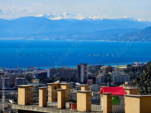 Genova, Italy - March 24, 2024: Aereal view to the city of Genoa with beautifull blue sea in the background. Sunny spring day over the city. Modern and old architecture mix.