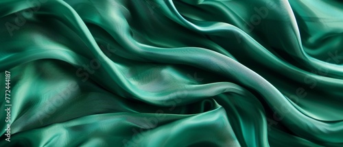 Smooth emerald green satin fabric draped in languorous waves, emphasizing the sleek and sumptuous look of the high-quality textile.