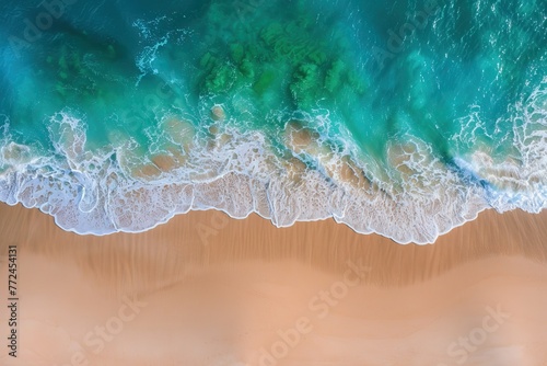 Aerial view of ocean waves meeting sandy beach