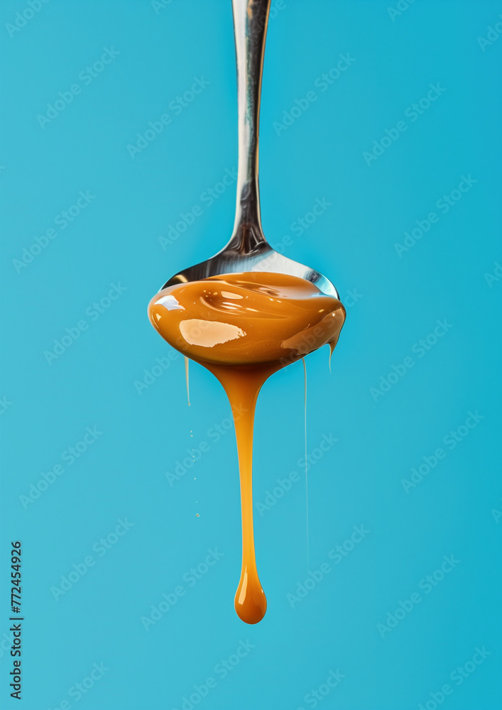 Close-up of a golden spoon overflowing with dripping, golden honey isolated on white background Close-up of a golden spoon overflowing with dripping, golden honey isolated on white background