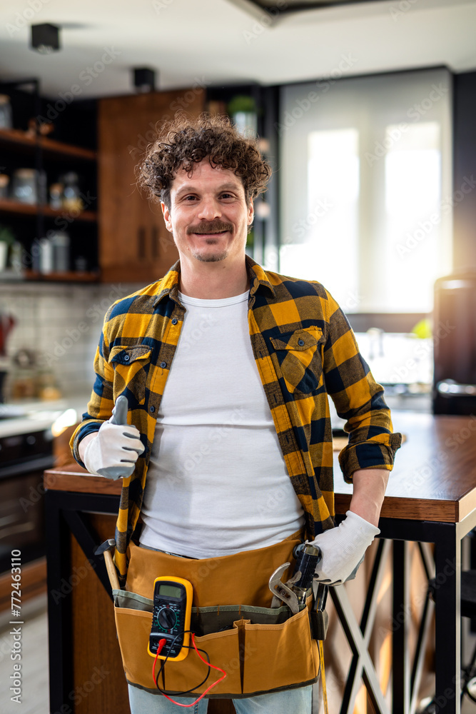 Obraz premium Portrait of Latino handyman. Standing in the kitchen with all the equipment.