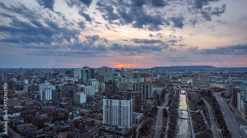 Aerial panoramic breathtaking view of sunset over Rideau Canal, Parliament Hill, downtown Ottawa, Ontario and Gatineau, Gatineau Park Hills, Outaouais, Quebec, Canada (Drone photo, April 2021) photo