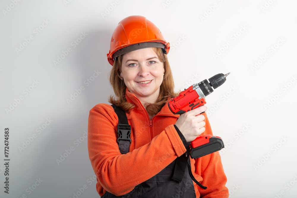 A portable cordless drill in the hands of a girl.A tool for the job . A portable cordless drill in the hands of a girl.A tool for the job .