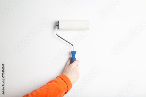 A painter girl with a roller for painting walls.. Painting the walls of the house.