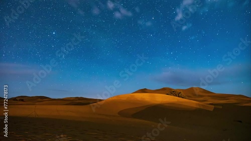 Amazing 4K timelapse of the stars in the night sky, the milkyway moving in a landscapes of the desert with dunes
