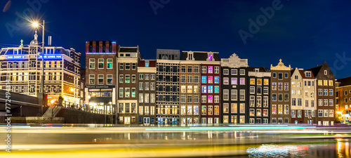 Night time shot of the Singel canal, Amsterdam with historic buildings along the bank and light flare