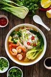 Shrimp Pho soup - Vietnamese soup with shrimps on wooden table
