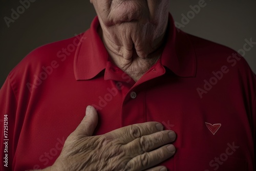 A middle-aged man in a red shirt clutches his chest in a gesture indicating pain, chest discomfort, and a heart attack. Cardiac emergency. Symptoms of a heart attack. Cardiovascular disease. Banner