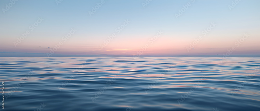 An expansive ocean view under a soft sunrise sky, blending hues of pink and blue