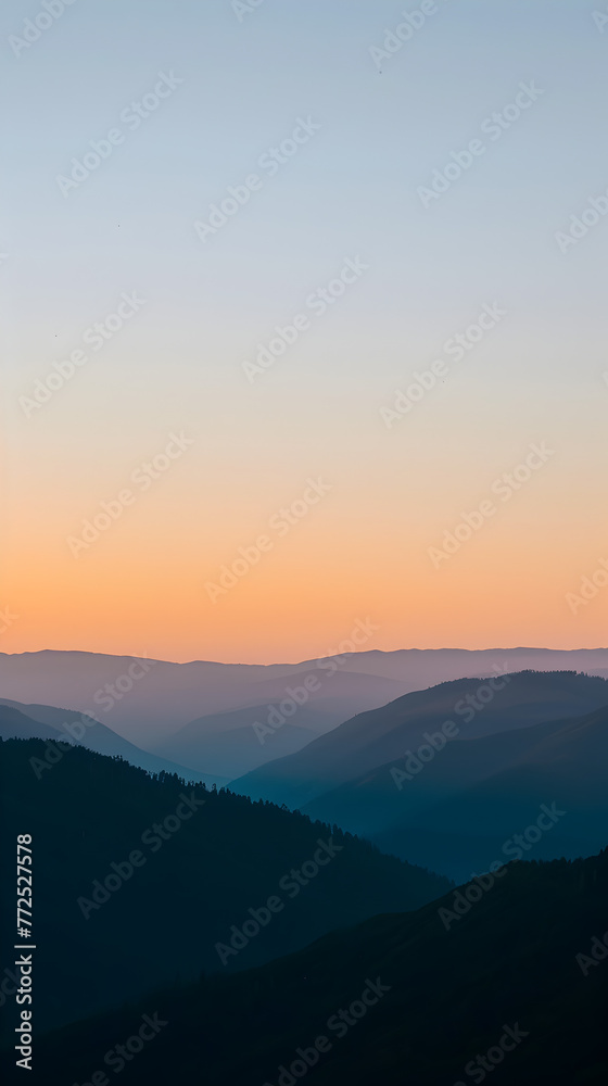 Layers of mountains receding into the distance under a smooth gradient evening sky