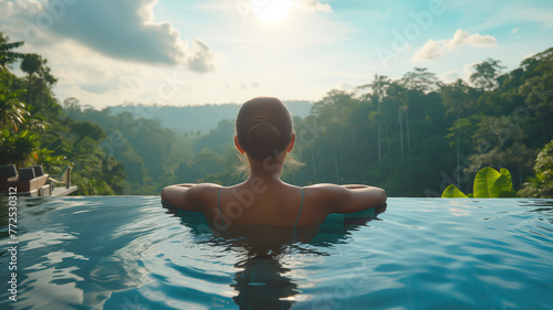 A woman in a swimming pool looks at the forest in front of her