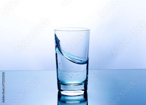 Splash of water in a glass on a blue background
