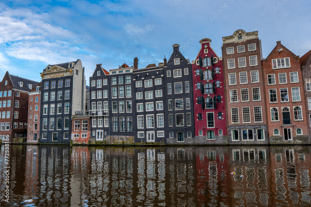 Amsterdam downtown - Amstel river, old houses and a bridge. Travel to Europe. Holland, Netherlands, Europe.