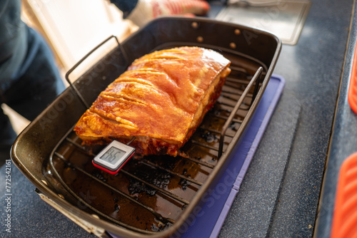 Shallow focus on the point where a thermometer enters a pork loin join so the temperature of the cooked meat can be measured.