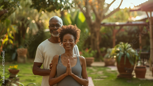 Healthy black senior couple in a garden practising yoga, praying and meditating photo