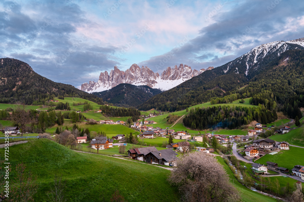 Sunset landscape with Santa Magdalena village against the Geisler mountains covered with snow, Val Di Funes valley in Dolomites mountains, South Tyrol, Italy. Italian Alps in springtime