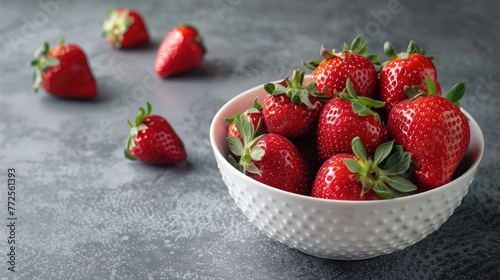 Ripe strawberries in a bowl on a gray background  juicy berries  vitamins.