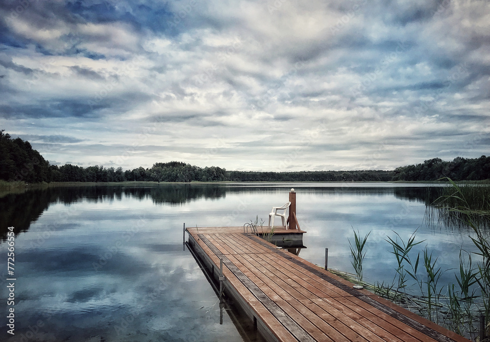 Naklejka premium wooden jetty on the lake in summer, tranquil atmosphere by the lake, calm atmosphere, quiet landscape, restful view, 