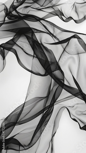 Fluttering chiffon and organza fabric in black and white. Translucent textiles with delicate movement.