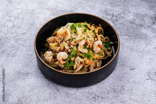 Pad Thai with shrimp in a plate on a gray background
