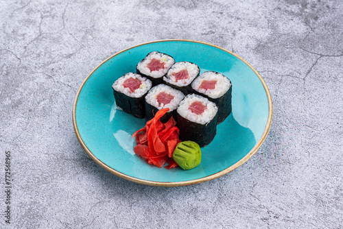 Maki sushi rolls with tuna in a plate on a gray background