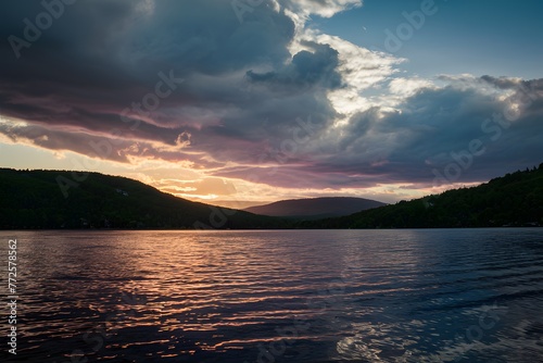 Sunset at the lake unfolds under dramatic dark clouds