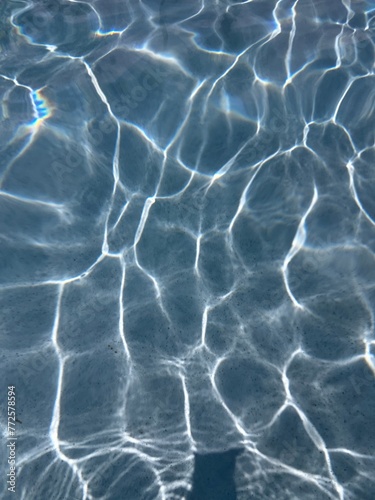 reflection if water in a pool with a dark blue bottom 