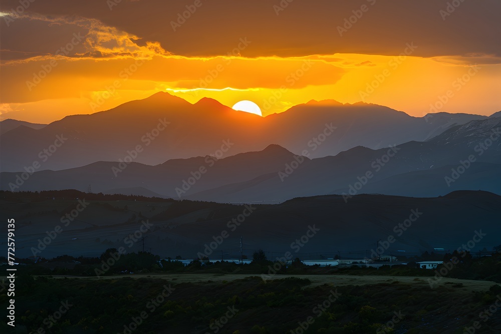 Sun sets behind majestic mountains, casting a golden hue Sun sets behind majestic mountains, casting a golden hue