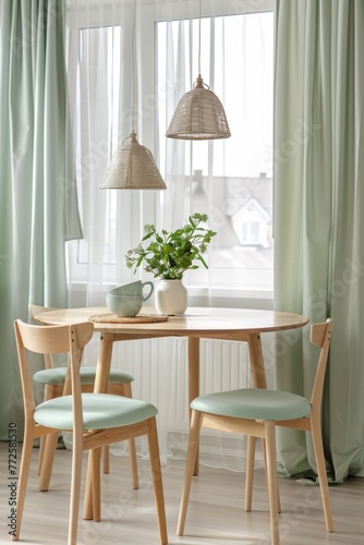 Cozy dining space with two mint chairs and wooden table under natural light