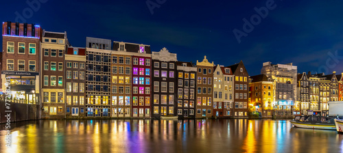 Night time shot of the Singel canal  Amsterdam with historic buildings along the bank and light flare