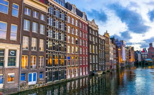Amsterdam canal Singel with typical dutch houses and houseboats during morning blue hour, Holland, Netherlands 