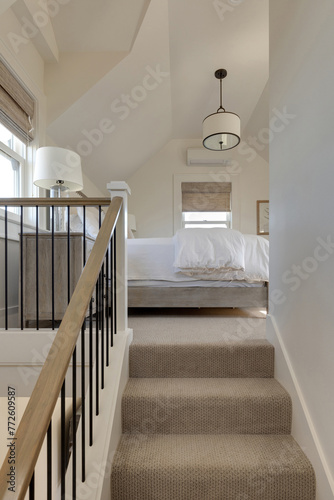 A cozy bedroom nestled atop wooden stairs in a traditional cottage, inviting with warm lighting and hints of rustic charm.