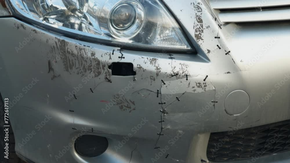 Driver attempts DIY repair on damaged car bumper, unprofessional fix