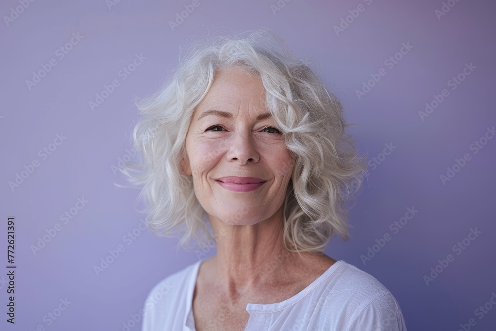 Portrait of a happy senior woman smiling at the camera against purple background Portrait of a happy senior woman smiling at the camera against purple background