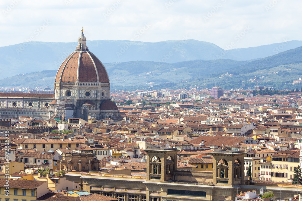 The iconic Duomo dominates the skyline of Florence, Italy, with its massive dome and bell tower overlooking a sea of terracotta roofs.