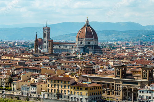 Florence Cathedral stands tall with its renowned dome and bell tower, presiding over the city's historic urban landscape.