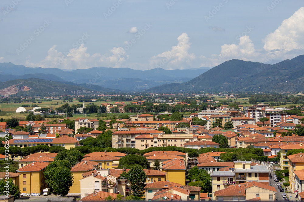 Overlooking the rooftops of Pisa, this landscape captures the essence of Italian charm with a backdrop of rolling Tuscan hills under a soft cloud-strewn sky