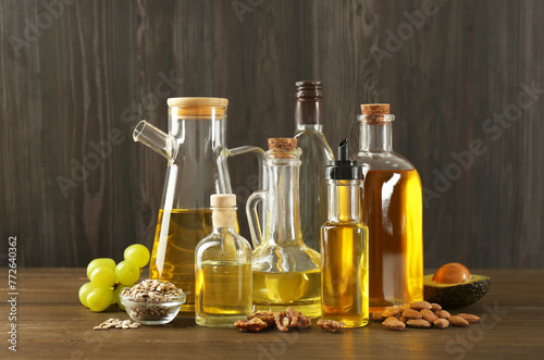 Vegetable fats. Different oils in glass bottles and ingredients on wooden table