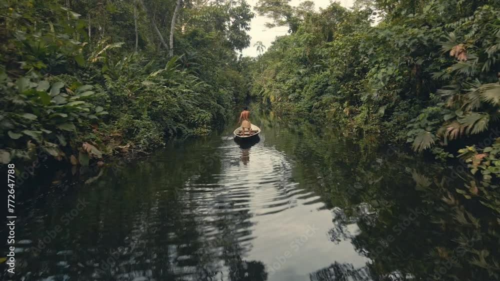 Back drone shot of a tribe man in a canoe Back drone shot of a tribe man in a canoe