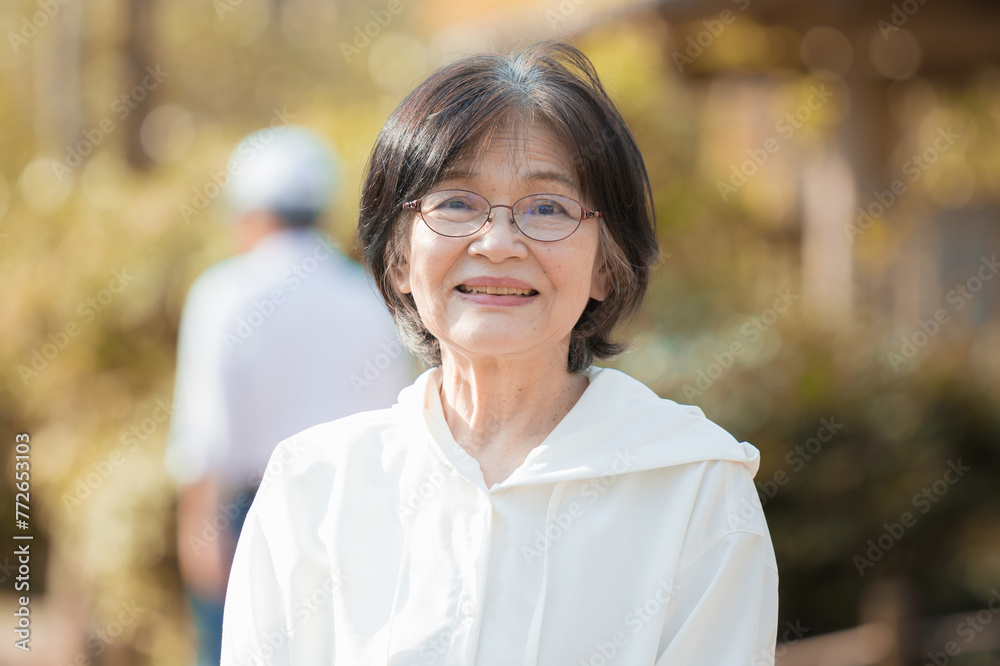 Close-up of a senior (elderly) woman with a natural, energetic smile in a backlit fall/winter outdoor setting for beauty, health, and health care images. Close-up of a senior (elderly) woman with a natural, energetic smile in a backlit fall/winter outdoor setting for beauty, health, and health care images.