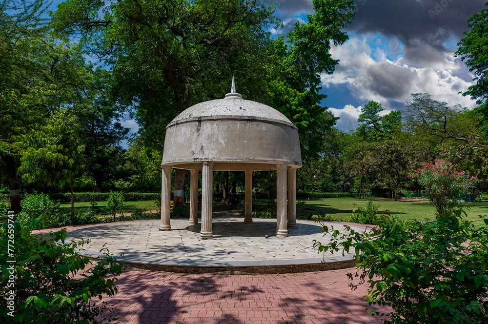 Classical Pavilion with Domed Roof in Serene Park, Lush Landscaping, Mature Trees, Partly Cloudy Sky