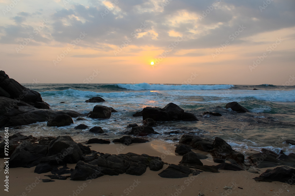 The sun setting into the sea at Delawella beach, Sri Lanka. Golden light