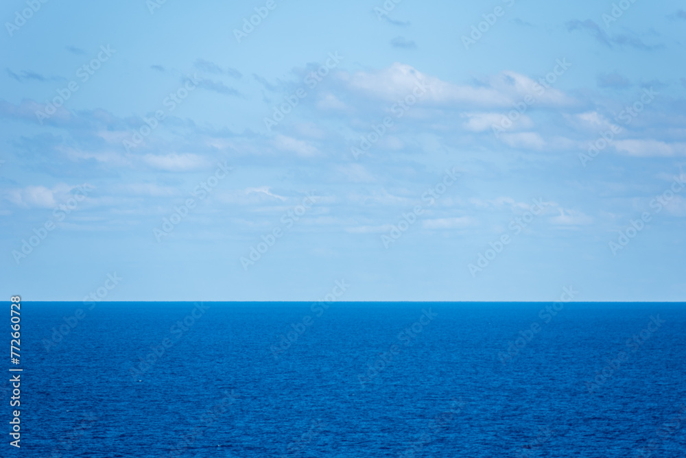 Calm Atlantic Ocean seascape, sunny day with gentle clouds on the sky. 