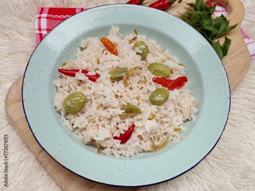 Nasi liwet or liwet rice. Rice cooked with spices such as bay leaves, galangal, shallots, garlic and chili. Once the rice is cooked, sprinkle with fried anchovies and fried petai. Closeup photo. photo