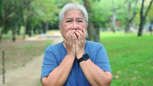 Panic shock horrified and crying elderly woman who witnessed the violent event caused negative fear showing frightened expression on her face using her hands cover her mouth frightening. photo