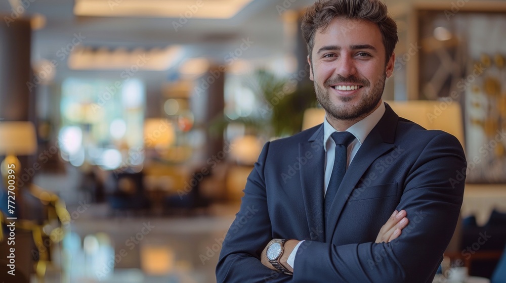 Casual businessman standing with hands in pocket in corporate office lobby, smiling.