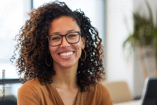 Cheerful Young Woman With Glasses Smiling in a Bright Office Environment During the Day