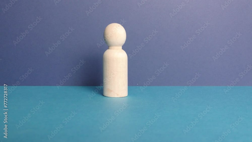 ensemble de petits personnages en bois déplacés par une main sur fond bleu
